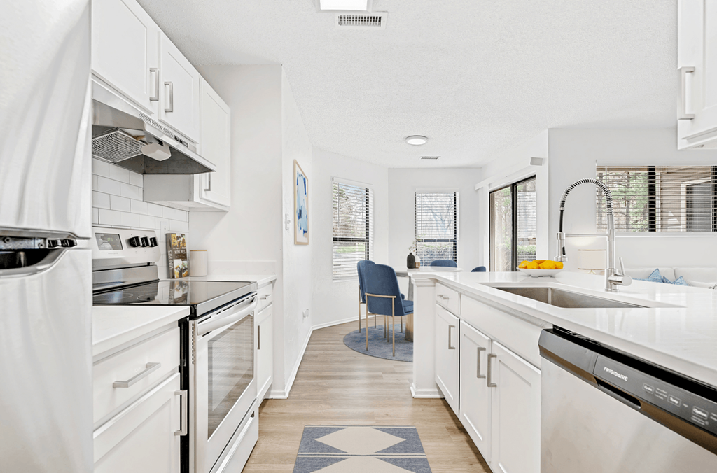 a kitchen with white cabinets and stainless steel appliances at Bridges at Mallard Creek Apartment Homes, North Carolina, 28269