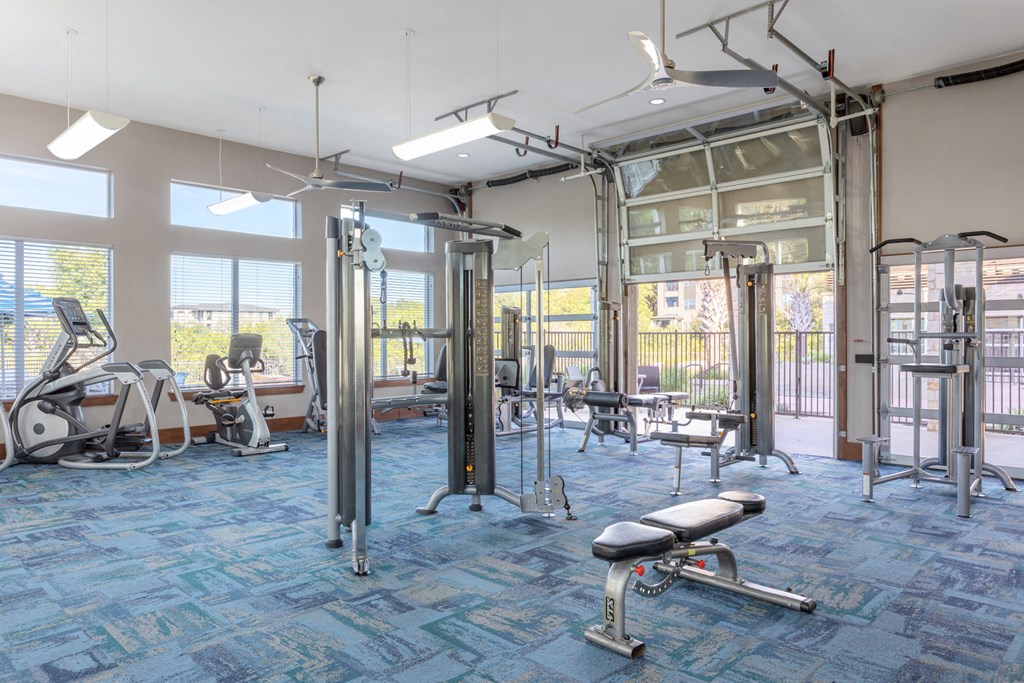 a gym with exercise equipment and windows