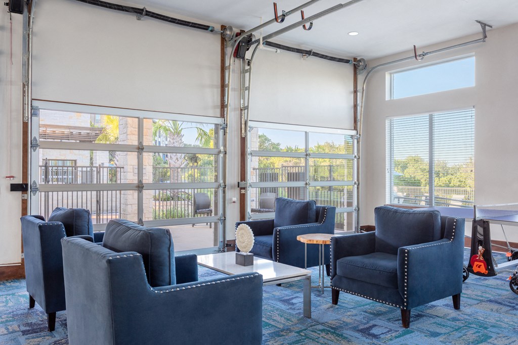 clubhouse with blue chairs and firehouse style garage doors