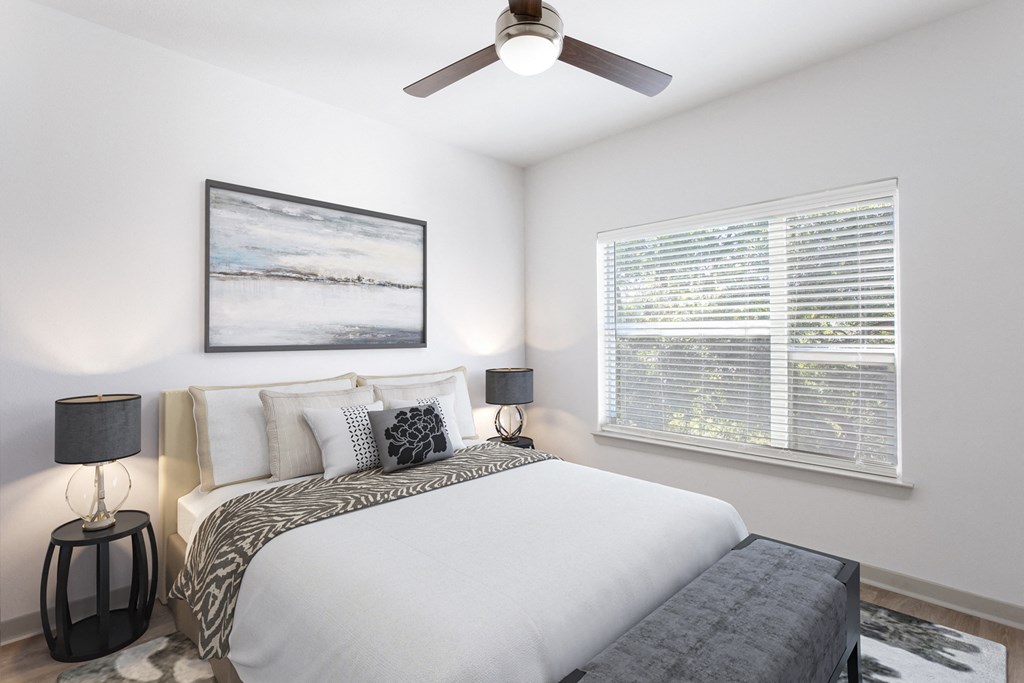 a bedroom with a large bed and a ceiling fan