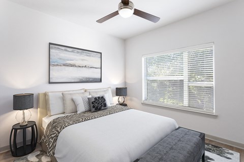a bedroom with a large bed and a ceiling fan
