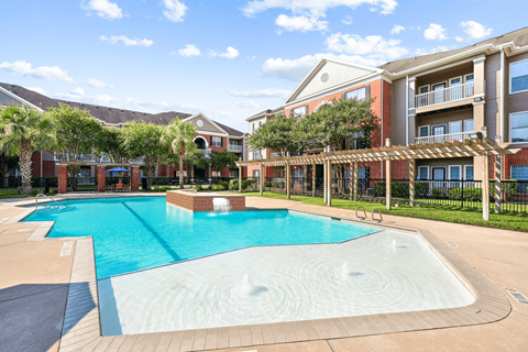 A large swimming pool in front of apartment buildings.