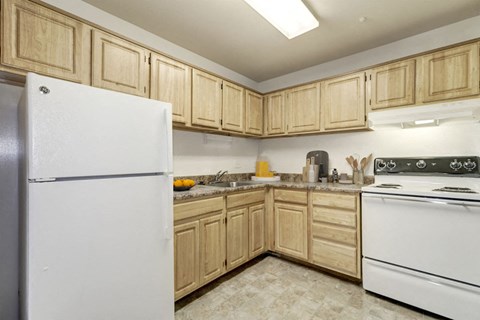 A kitchen with wooden cabinets and a white refrigerator.