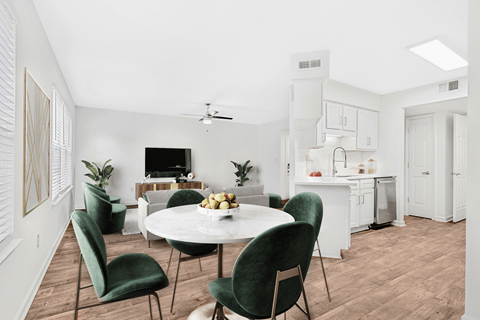 a living and dining area with a white table and green chairs