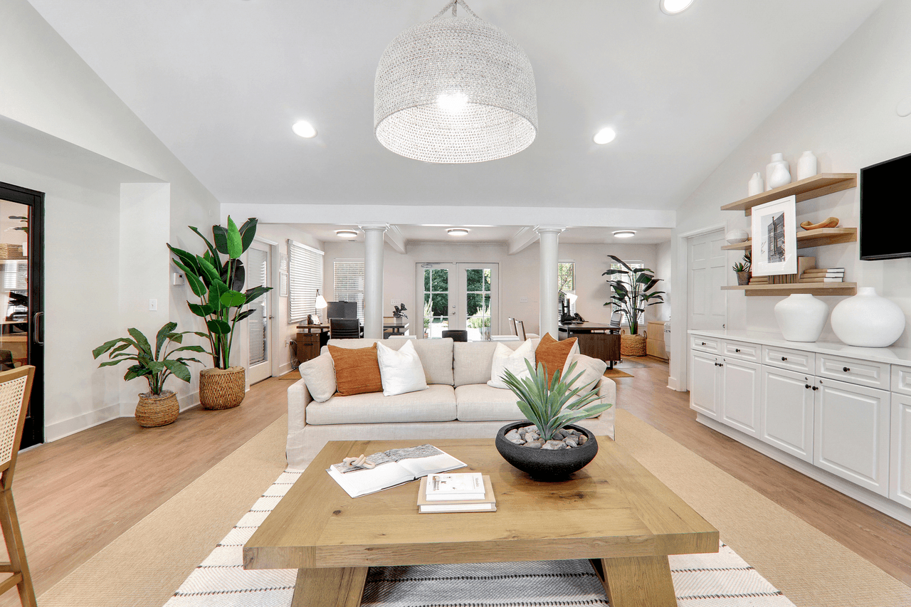 A living room with a white couch and a wooden coffee table.