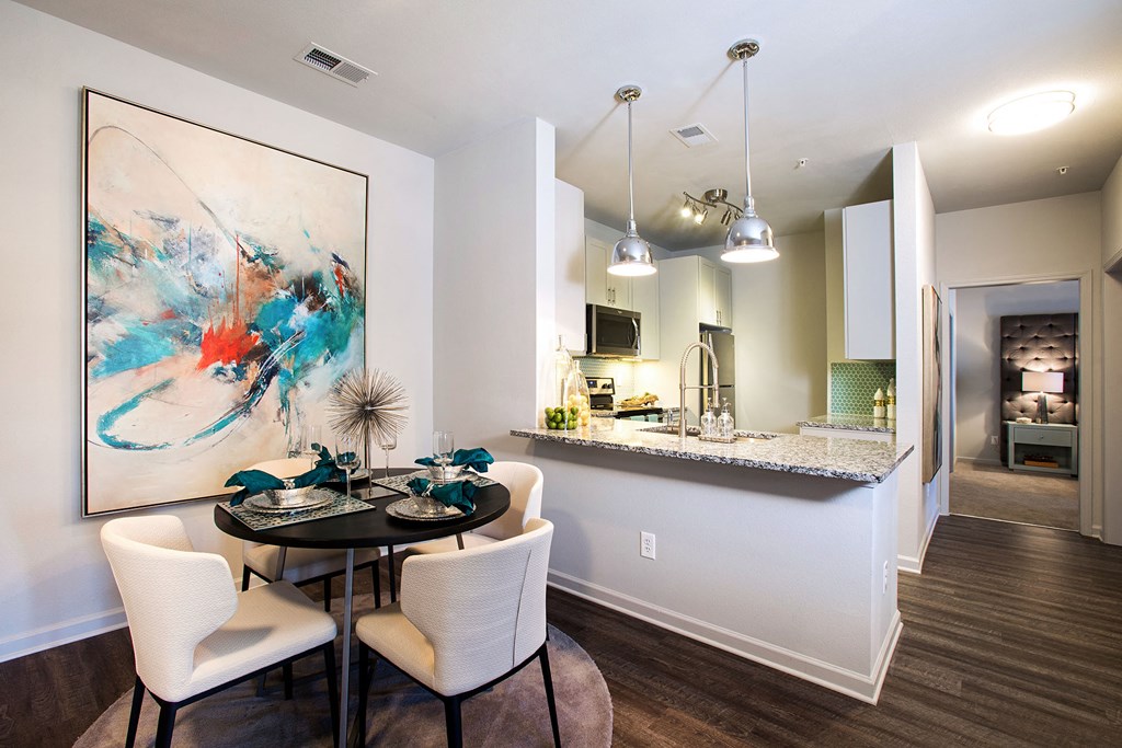 a dining room and kitchen with a table and chairs