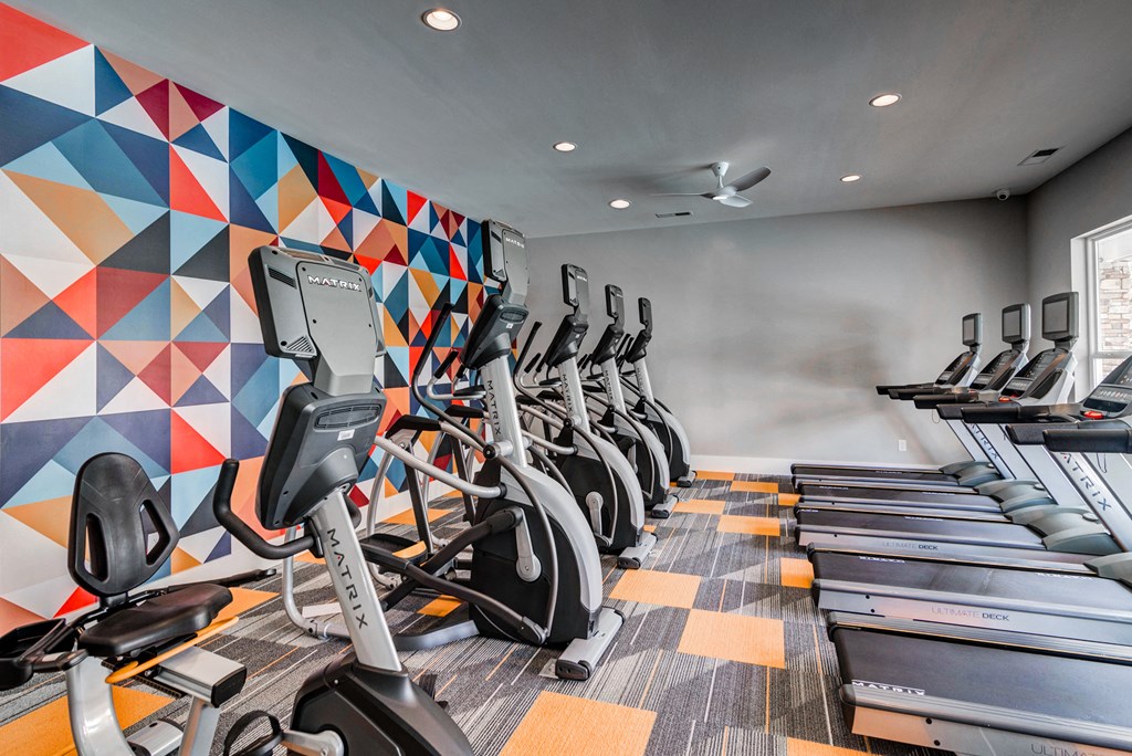 a row of cardio exercise machines in a gym