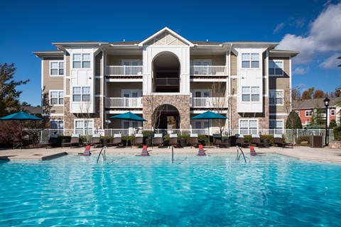 a large swimming pool in front of an apartment building