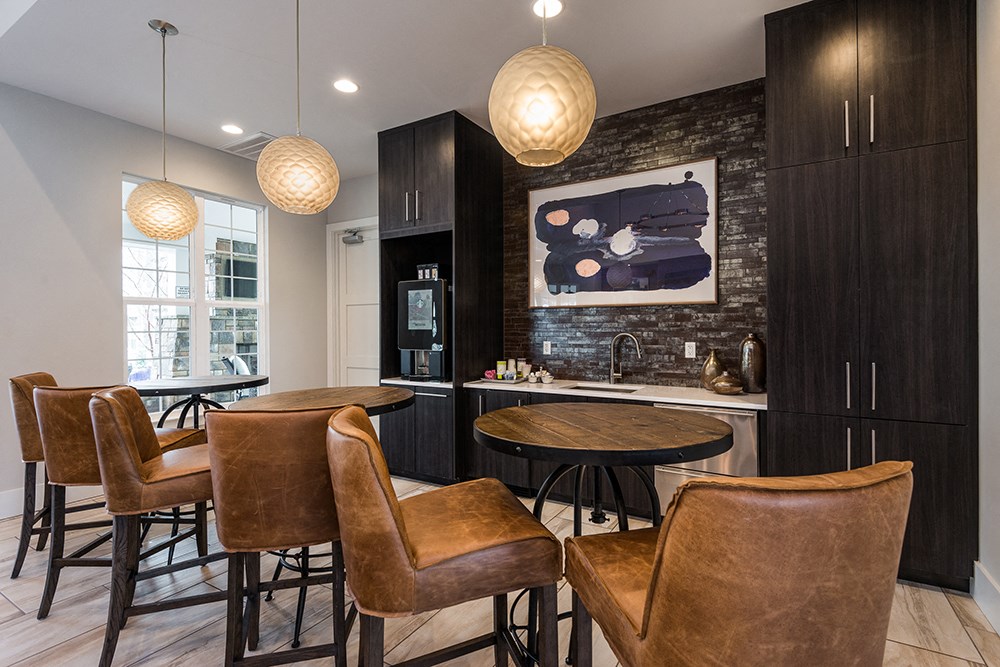 a kitchen and dining area with leather chairs and a table