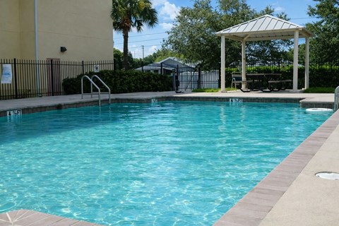 A pool with a gazebo in the background.