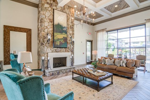 A living room with a stone fireplace and a painting above it.