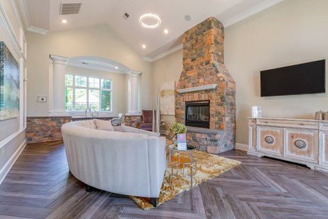 the living room has a large stone fireplace and a white couch