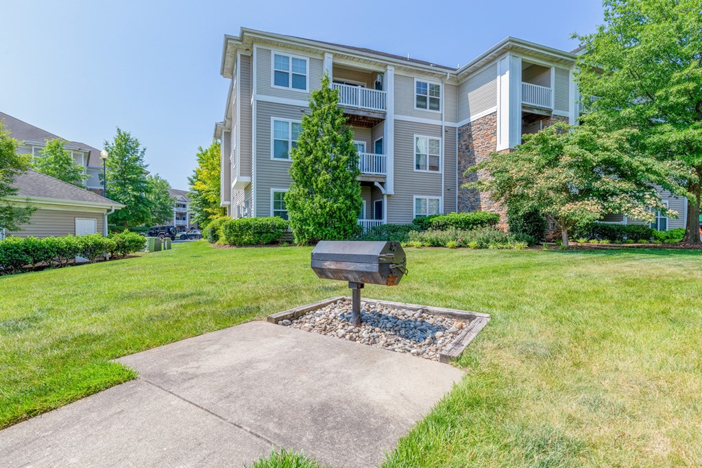 grill with grass area and apartments in the background