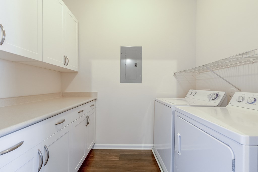 a laundry room with white cabinets and a washer and dryer
