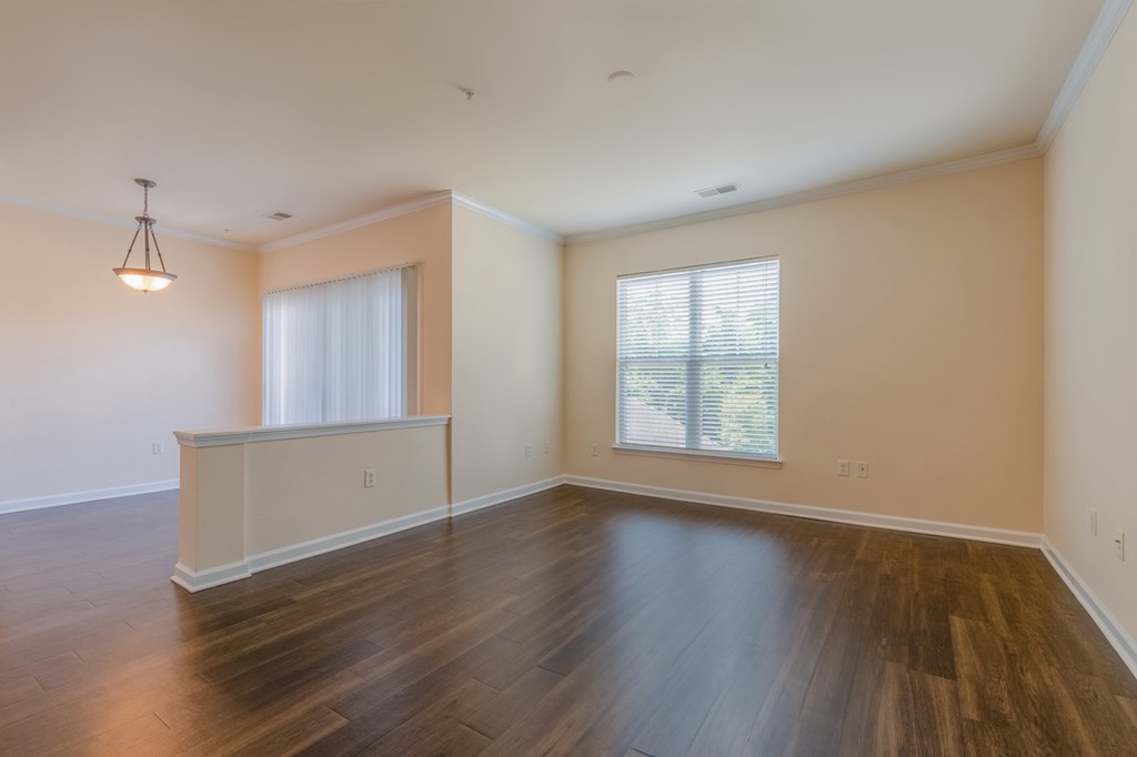 an empty living room with hardwood floors and a window