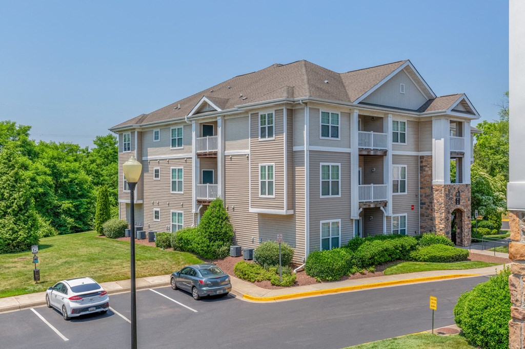a large apartment building with cars parked in front of it