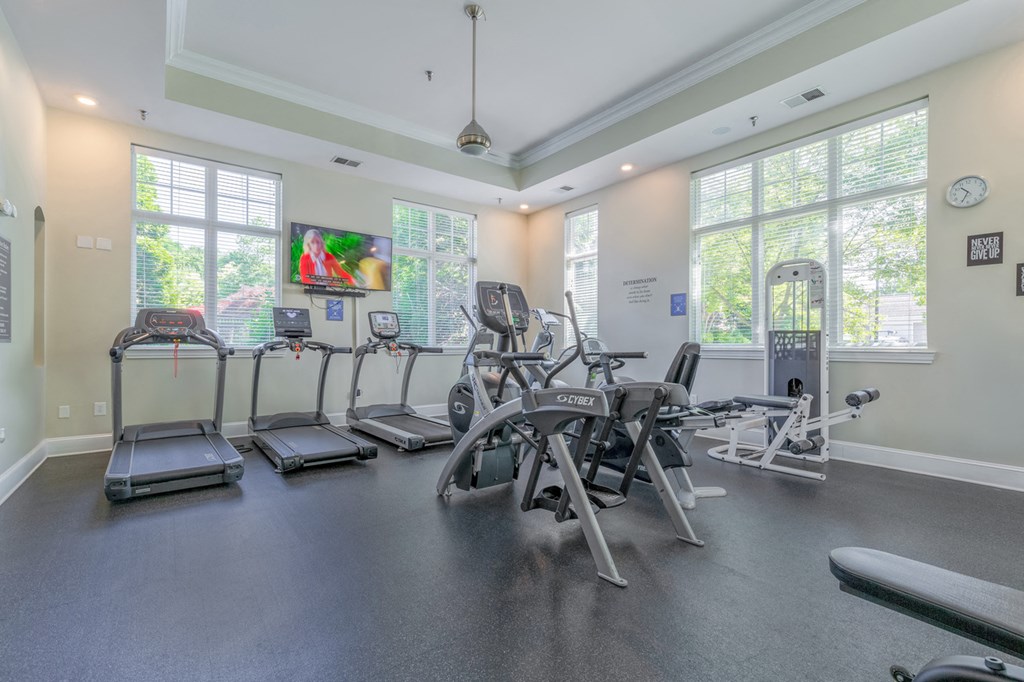 the gym with cardio equipment and windows