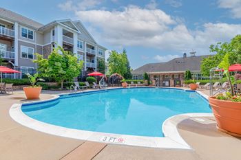 a swimming pool with an apartment building in the background