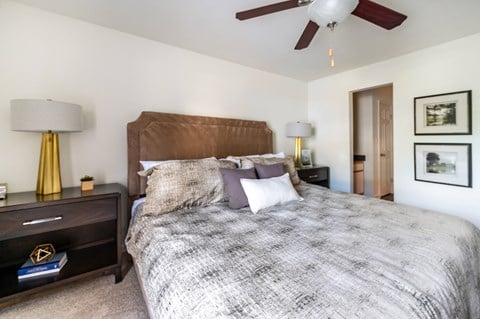 A bedroom with a large bed and a ceiling fan.