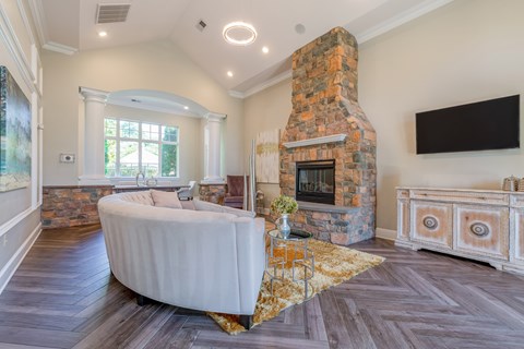 A living room with a stone fireplace and a large white sofa.