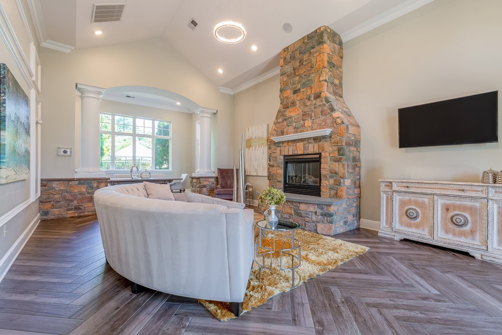 A living room with a stone fireplace and a large white sofa.
