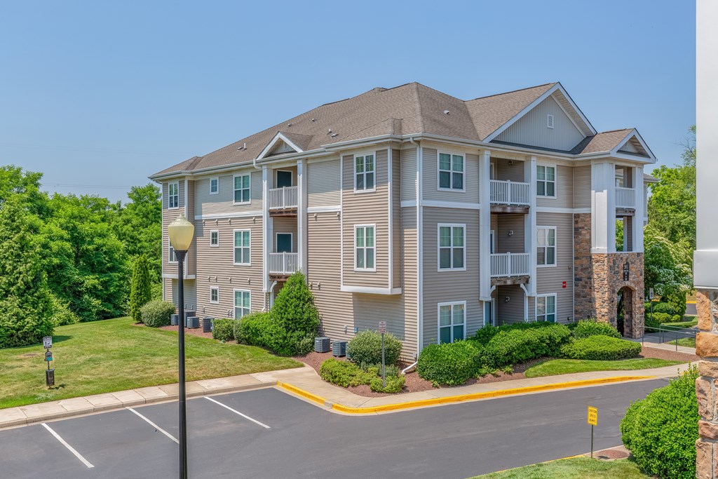 A large apartment building with a parking lot in front.