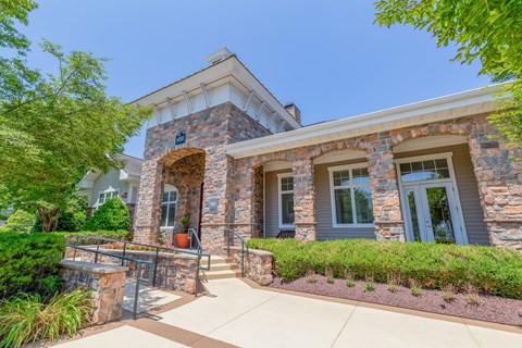 A house with a stone facade and a grey roof.
