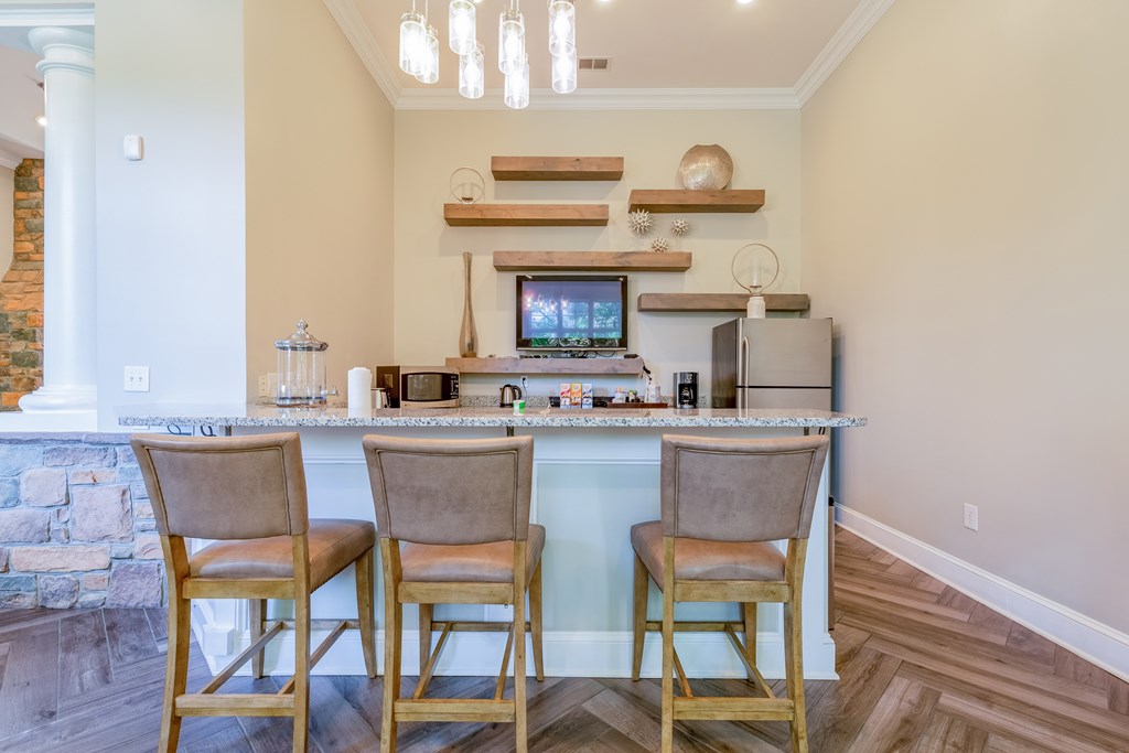 A kitchen with a stone fireplace and a TV above the counter.