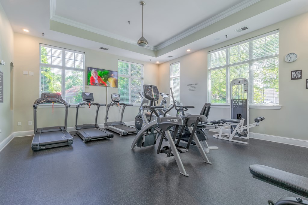 A spacious gym with treadmills, elliptical machines, and weight machines.