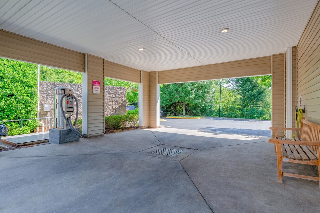 A large, empty room with a wooden bench and a playground in the background.