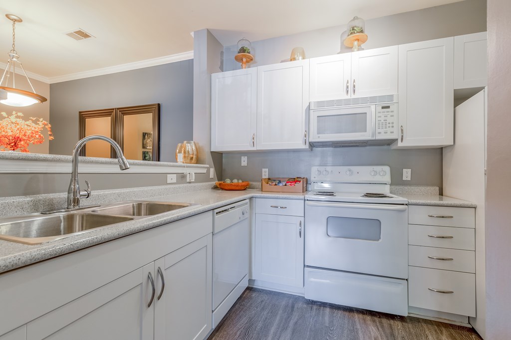A kitchen with white cabinets and appliances.