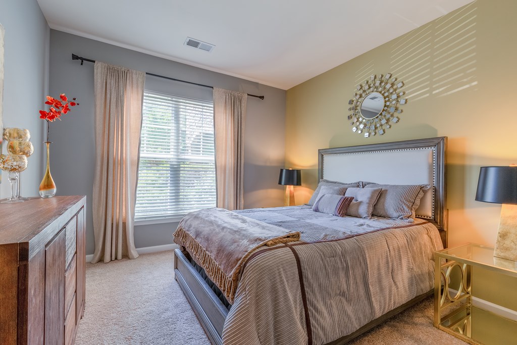 A bedroom with a large bed and a clock on the wall.
