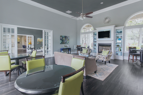A modern living room with a glass table and yellow chairs.