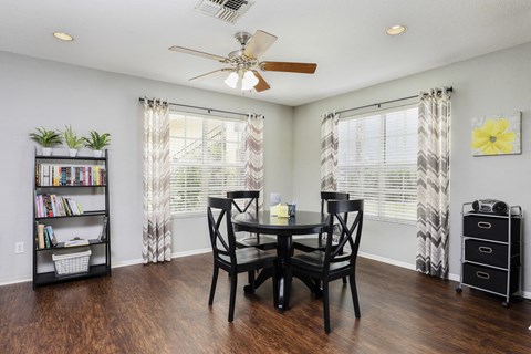 a dining room with a table and chairs and a ceiling fan