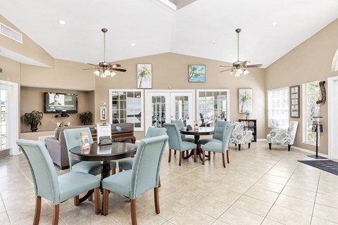 Interior of clubhouse facing a common area with chairs and tables