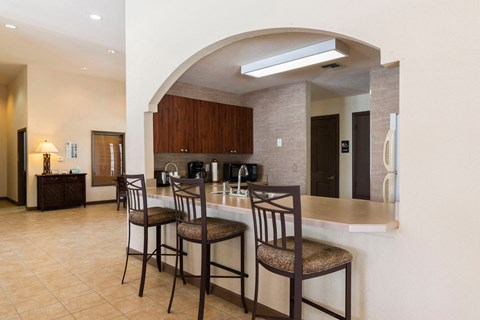 A kitchen with a bar area and chairs.