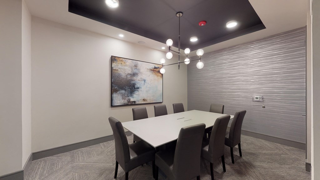 Resident conference room with a long table facing a painting