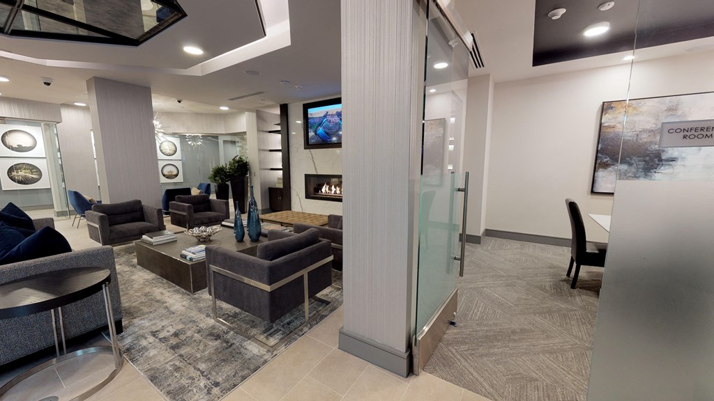 Interior of resident clubhouse facing common area with chairs and a table