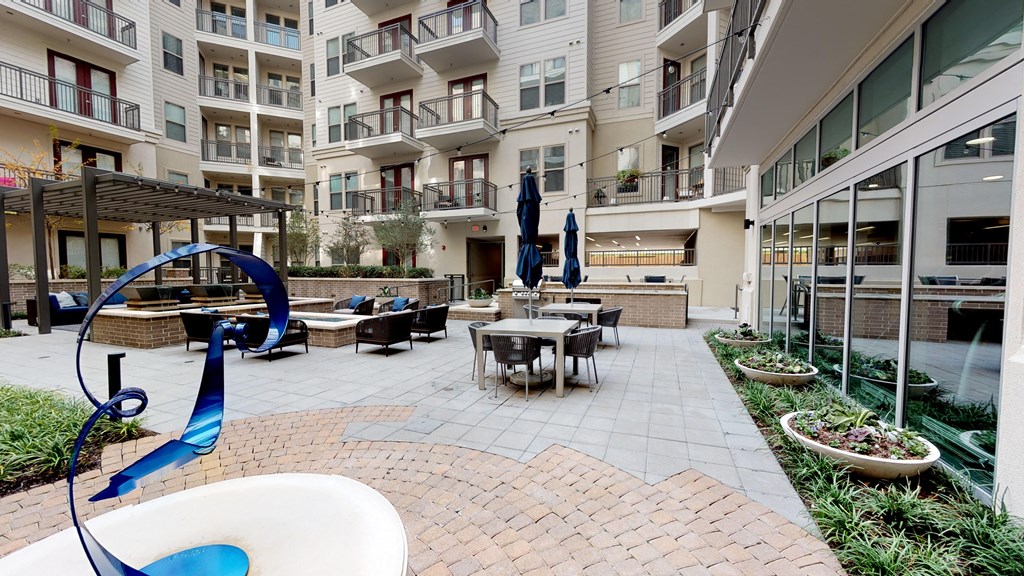 Outdoor seating areas next to sculpture and courtyard.