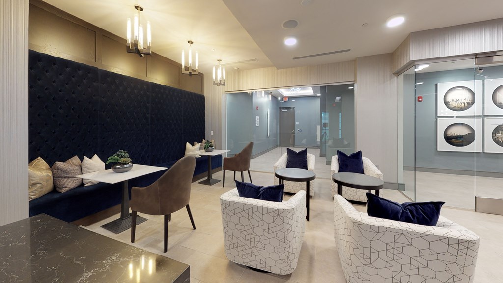 Resident clubhouse common area with a table and white chairs