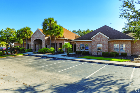 A parking lot in front of a building with a clear blue sky.