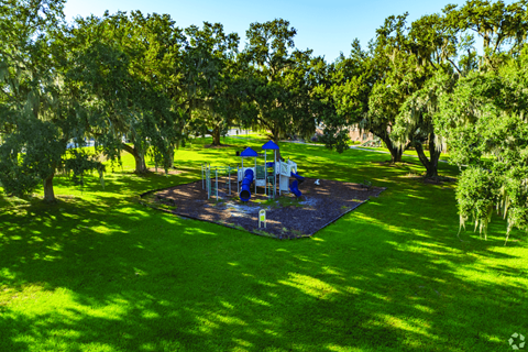 A playground with a blue slide and a blue and white swing set.