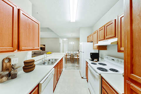 A kitchen with wooden cabinets and white appliances.