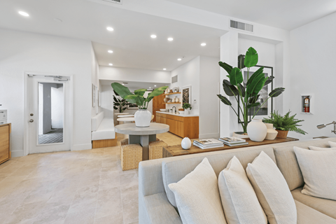 A living room with a white couch and a wooden coffee table.