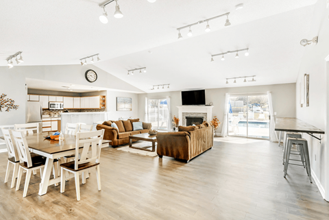 A modern living room with a dining table and a fireplace.