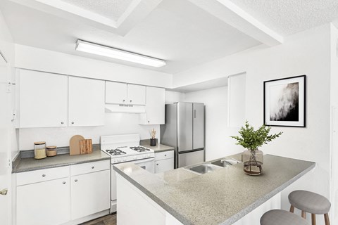 A kitchen with white cabinets and a granite countertop.