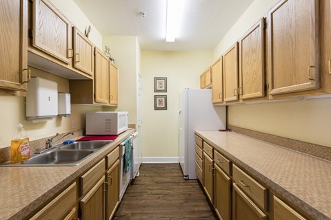 A kitchen with wooden cabinets and a white refrigerator.
