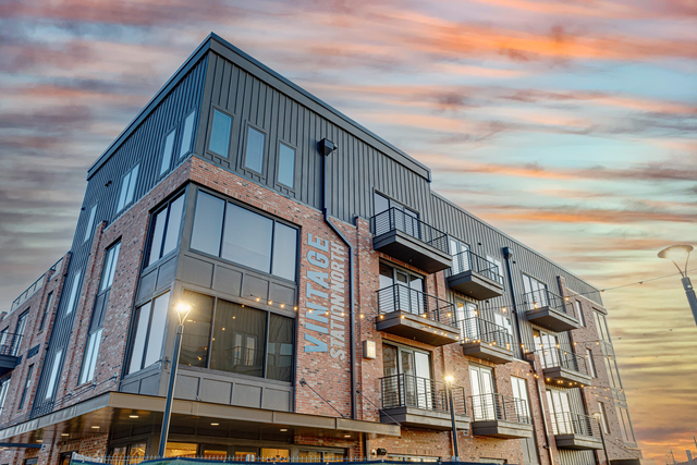an apartment building with a sunset in the background
