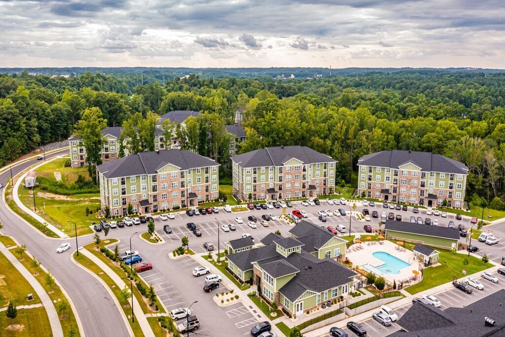 A large apartment complex with a swimming pool in the middle of a parking lot at Foxwood Apartments, North Carolina