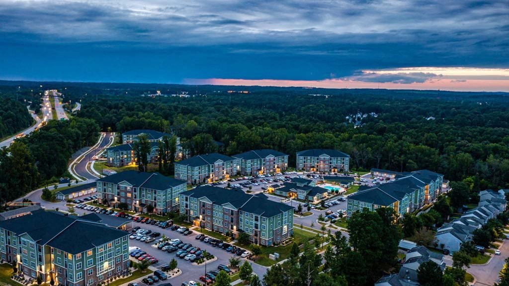 A large resort with multiple buildings and a parking lot is shown in the image at Foxwood Apartments, Raleigh-Durham, NC, 27616